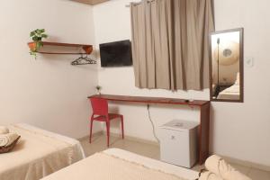 a room with two beds and a mirror and a chair at Pousada Casa Boa Milagres a beira mar ideal para curtir a Rota dos Milagres in Barra do Camaragibe