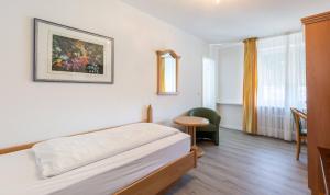 a hotel room with a bed and a table at Hotel Keller in Kreuztal