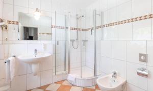 a white bathroom with a shower and a sink at Hotel Keller in Kreuztal