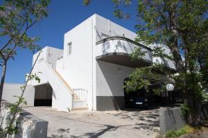 a white building with a staircase on the side at Fay's Studios Leros in Lakkíon
