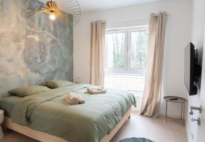 a bedroom with a bed with two towels on it at Les Villas de l'Ill in Didenheim