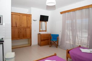 a bedroom with a bed and a dresser and a mirror at Fay's Studios Leros in Lakkíon