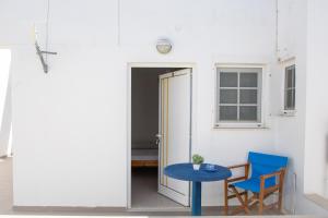 a blue table and a blue chair next to a door at Fay's Studios Leros in Lakkíon