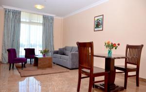 a living room with a couch and a table and chairs at Melodie Hotel in Addis Ababa