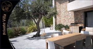 a table and chairs and a tree in a house at Cassis Lodges in Cassis