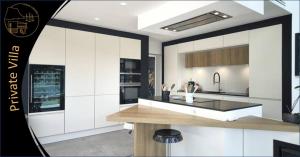 a kitchen with white cabinets and a kitchen island at Cassis Lodges in Cassis