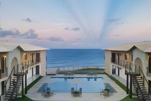 a view of a swimming pool with the ocean in the background at Sea View + Pool | Cliffs Mar 209 in Pipa