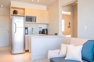 a kitchen with a couch and a refrigerator in a room at Sea View + Pool | Cliffs Mar 209 in Pipa