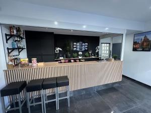 a bar with black stools in a restaurant at Hotel Le royal in Tulle