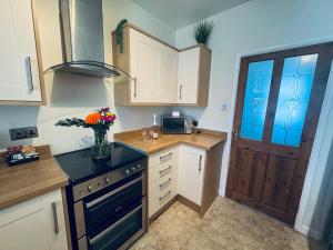 a kitchen with a vase of flowers on the counter at Lonsdale Terrace - 3 Bedrooms - Sleeps 6 in Workington +26 photos