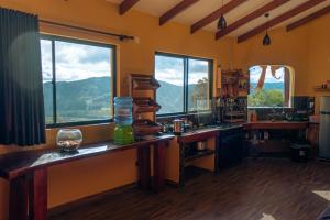 a kitchen with two windows and a view of a mountain at Cabaña Los Guapurús in Samaipata