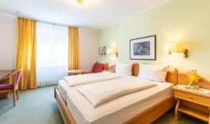 a hotel room with a large bed and a desk at Hotel Keller in Kreuztal