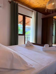 a white bed with two towels on top of it at Xhoni House in Elbasan