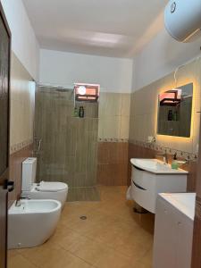 a bathroom with a tub and a sink and a toilet at Xhoni House in Elbasan +27 photos