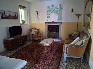 a living room with a couch and a fireplace at Villa Rosalena in Bagni di Lucca
