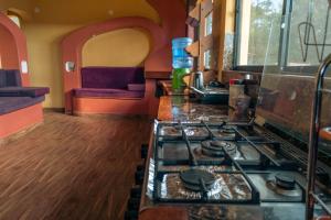a kitchen with a stove and a couch at Cabaña Los Guapurús in Samaipata +12 photos