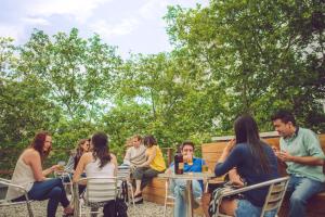 un grupo de personas sentadas en mesas en un jardín en Che Lagarto Hostel Montevideo en Montevideo