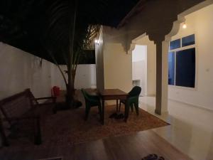 a table and chairs in a living room at night at Sun house kendwa beach in Kendwa