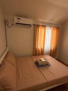 a small bedroom with a bed with a window at A&F Transient House in San Felipe