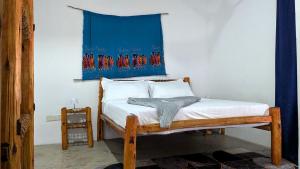 a bedroom with a bed with a blue curtain on the wall at The Hub Train House Hakuna Matata in Zanzibar City