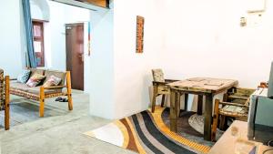 a dining room with a wooden table and chairs at The Hub Train House Hakuna Matata in Zanzibar City