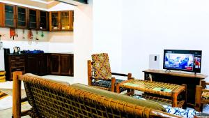 a living room with a couch and a television at The Hub Train House Hakuna Matata in Zanzibar City