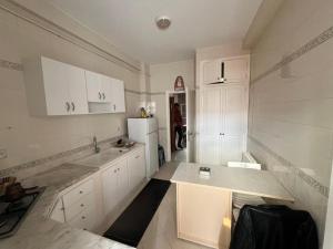 a kitchen with white cabinets and a white refrigerator at La Marsa in El Aouina Station