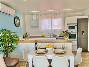 a kitchen with a white table and white chairs at Apartamento Mart in Miami Platja +5 photos