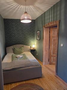 a bedroom with a bed and a chandelier at Apartment 2 im Martinsgarten Angermünde in Angermünde