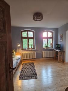a room with a bed and two windows at Apartment 2 im Martinsgarten Angermünde in Angermünde