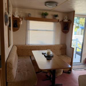 a small living room with a table and a couch at Jackson Home from Home Holidays in Little Clacton