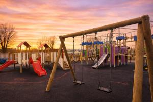 a playground with slides and swings in a park at Jackson Home from Home Holidays in Little Clacton