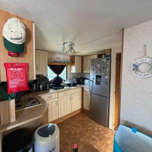 a kitchen with a stainless steel refrigerator and cabinets at Jackson Home from Home Holidays in Little Clacton