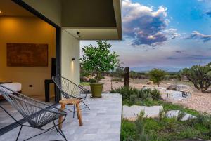 a patio with chairs and a view of the desert at Villa Lua, 2BR Countryside Bungalows for 6 Guests in La Talega