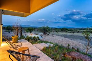 a patio with chairs and a view of a field at Villa Lua, 2BR Countryside Bungalows for 6 Guests in La Talega