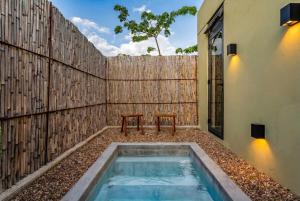 a pool with two benches in front of a fence at Villa Lua, 2BR Countryside Bungalows for 6 Guests in La Talega