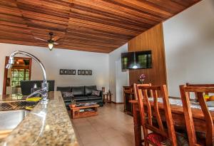 cocina y sala de estar con sofá y mesa en Entre a Lagoa e o Mar, en Florianópolis