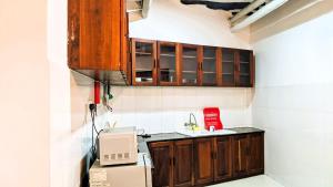 a small kitchen with wooden cabinets and a sink at The Hub Train House Hakuna Matata in Zanzibar City +22 photos
