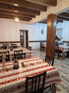 a dining room with tables and chairs with a view of the ocean at Casa Bunicilor in Gîrbova
