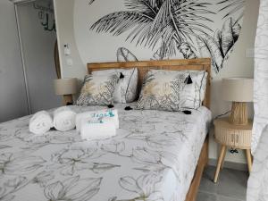 a bedroom with a bed with towels on it at Le léza - Terrasse et plage à 1 min in Les Trois-Îlets