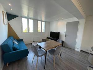 a living room with a blue couch and a table at LEvasion de Brest - Près du Tram - 5 Voyageurs in Brest