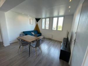 a living room with a table and a blue couch at LEvasion de Brest - Près du Tram - 5 Voyageurs in Brest