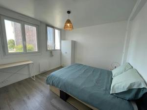 a bedroom with a bed and a desk and windows at LEvasion de Brest - Près du Tram - 5 Voyageurs in Brest