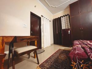 a bedroom with a desk and a bed and a chair at The Bel - Monte Stays in Panchkula