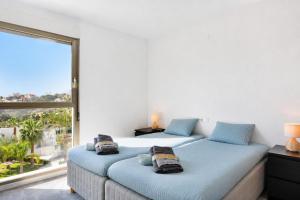 two beds in a bedroom with a large window at Exquisite Costa Blanca Escape Townhouses in El Campello