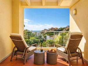 two chairs and a table in front of a large window at Exquisite Costa Blanca Escape Townhouses in El Campello