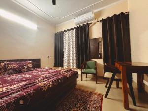 a bedroom with a bed and a desk and a table at The Bel - Monte Stays in Panchkula