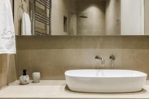 a bathroom with a white sink and a mirror at Cavo Mare Skopelos in Skopelos Town