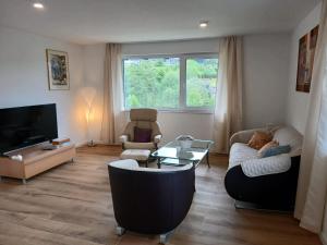 a living room with a couch and a tv at Ferienwohnung Buchenblatt in Simmerath
