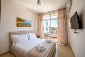 a bedroom with a bed and a large window at Parid Apartments in Sarandë